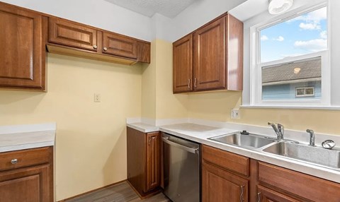 A kitchen with wooden cabinets and a window.