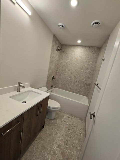 A bathroom with a sink, toilet and bathtub.