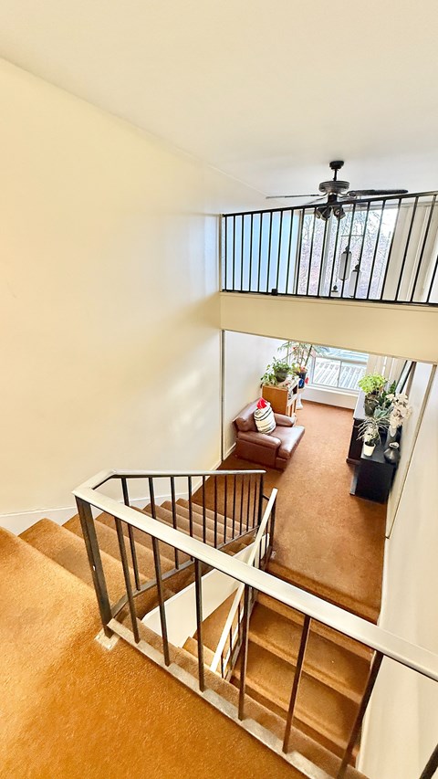 A hallway with white shelves on the right and a door on the left.