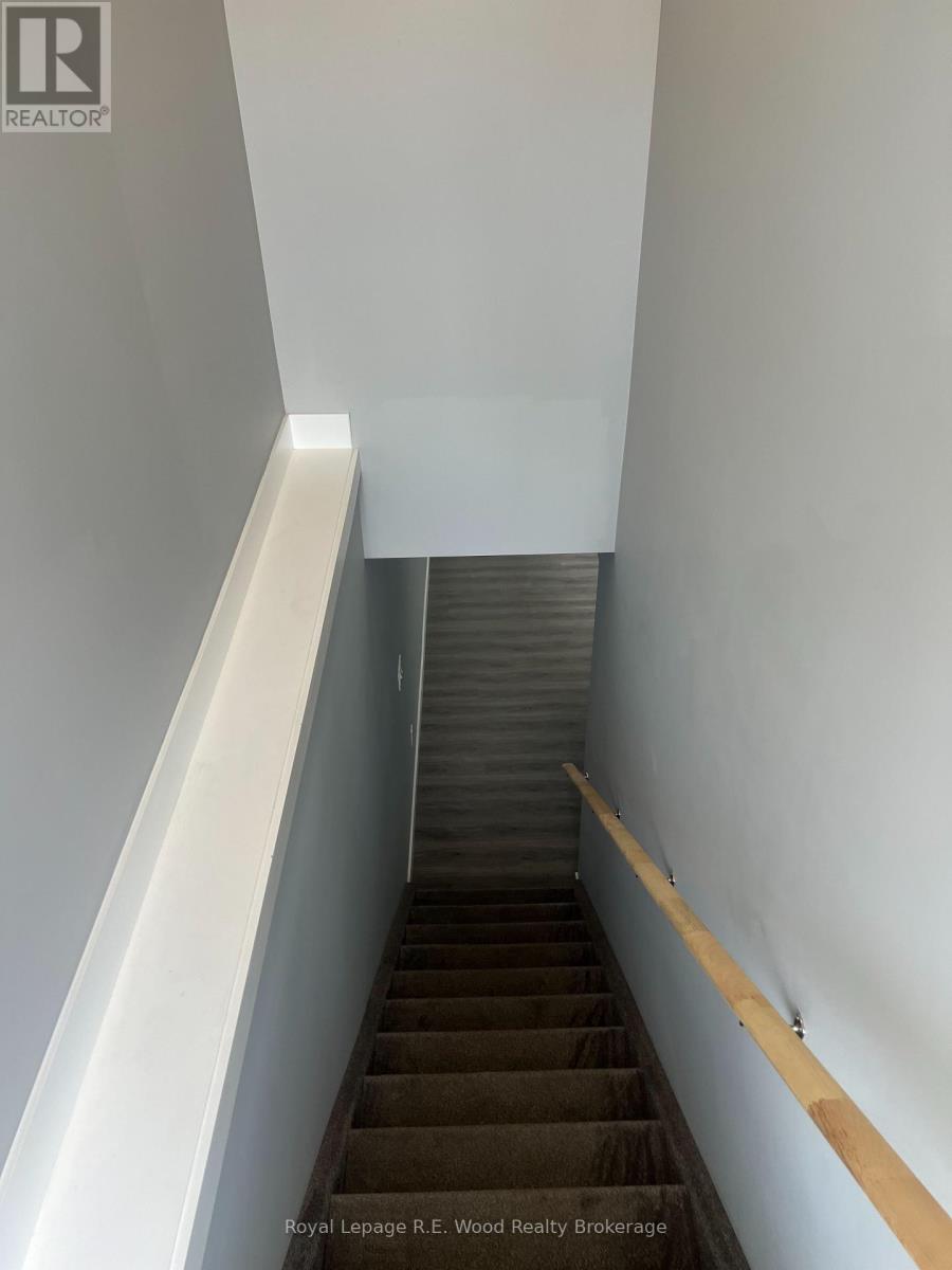 A staircase with a wooden handrail and a white wall on the side.