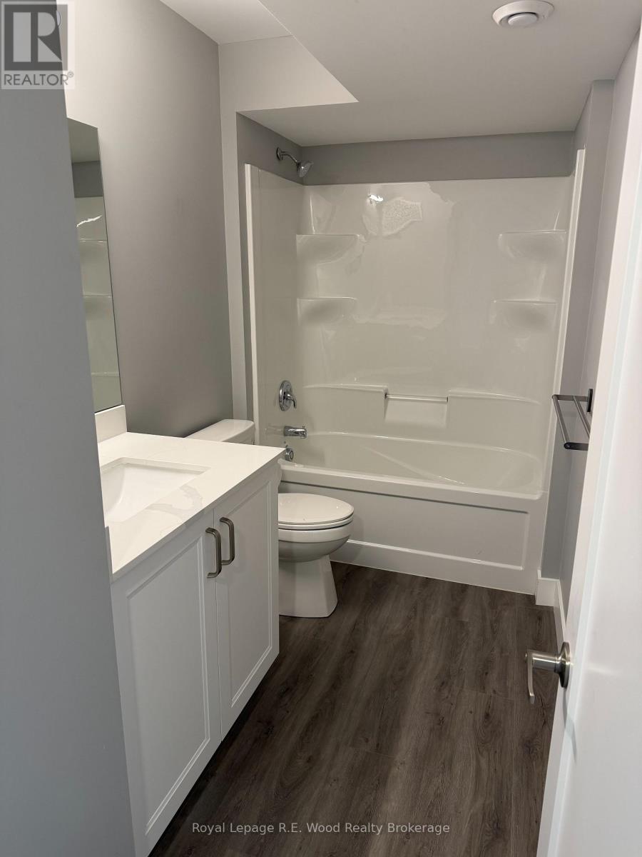 A white bathroom with a toilet, sink, and bathtub.