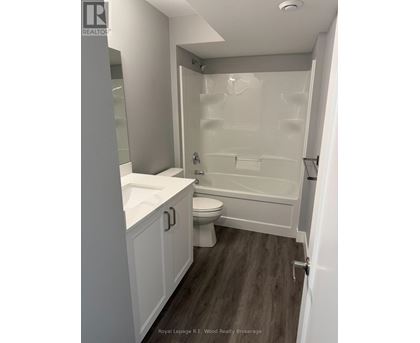 A white bathroom with a toilet, sink, and bathtub.