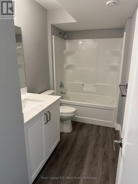 A white bathroom with a toilet, sink, and bathtub.
