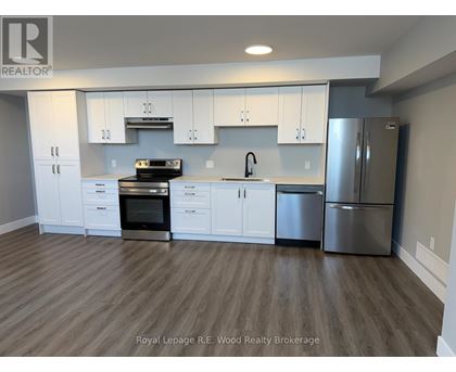 A modern kitchen with white cabinets and stainless steel appliances.