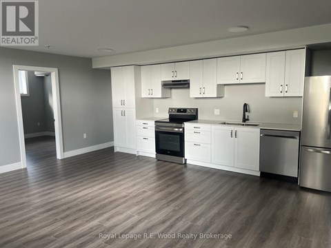 A modern kitchen with white cabinets and stainless steel appliances.