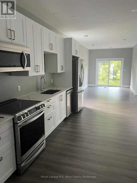 A modern kitchen with white cabinets and stainless steel appliances.