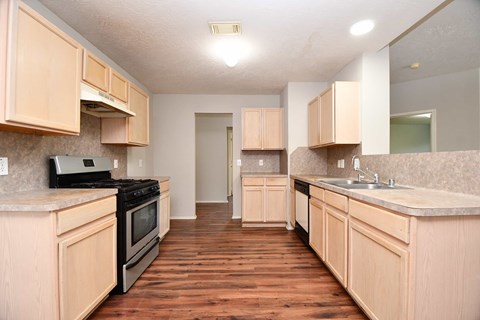 A kitchen with wooden cabinets and a black stove top oven.