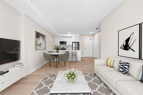 A living room with a white couch and a coffee table in the middle.
