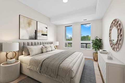 A bedroom with a large bed, a lamp, and a mirror on the wall.