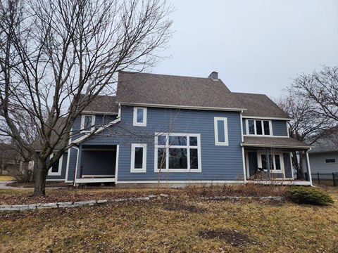 A blue house with a tree in front.