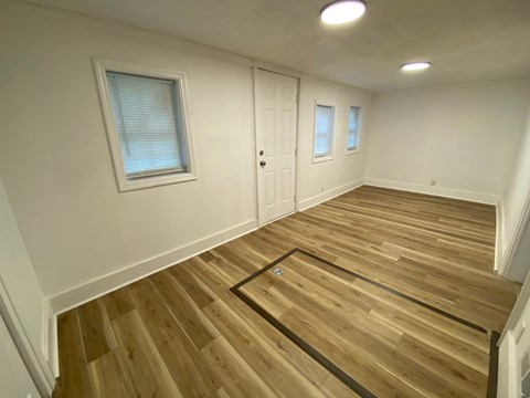 A room with wooden flooring and a white door.