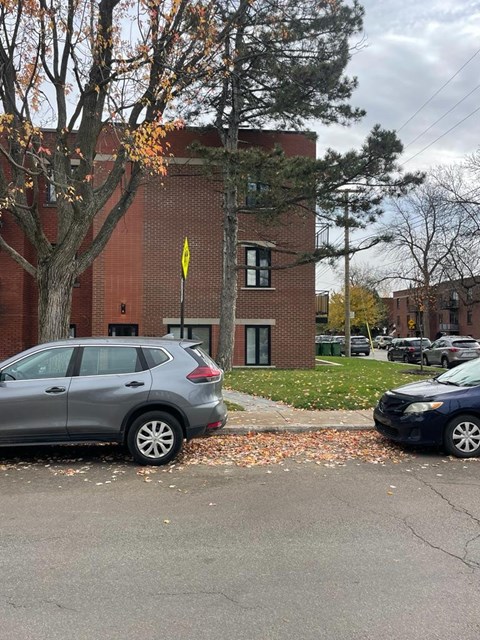 A grey car is parked on the side of a street.