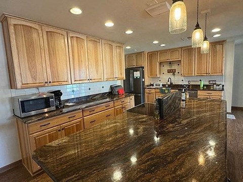 A kitchen with wooden cabinets and a granite countertop.