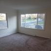 A room with a carpeted floor and a window.