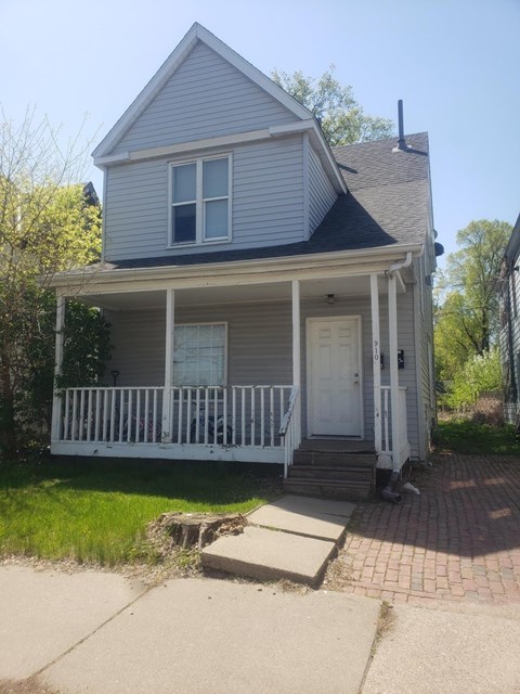 A small house with a white door and a porch.