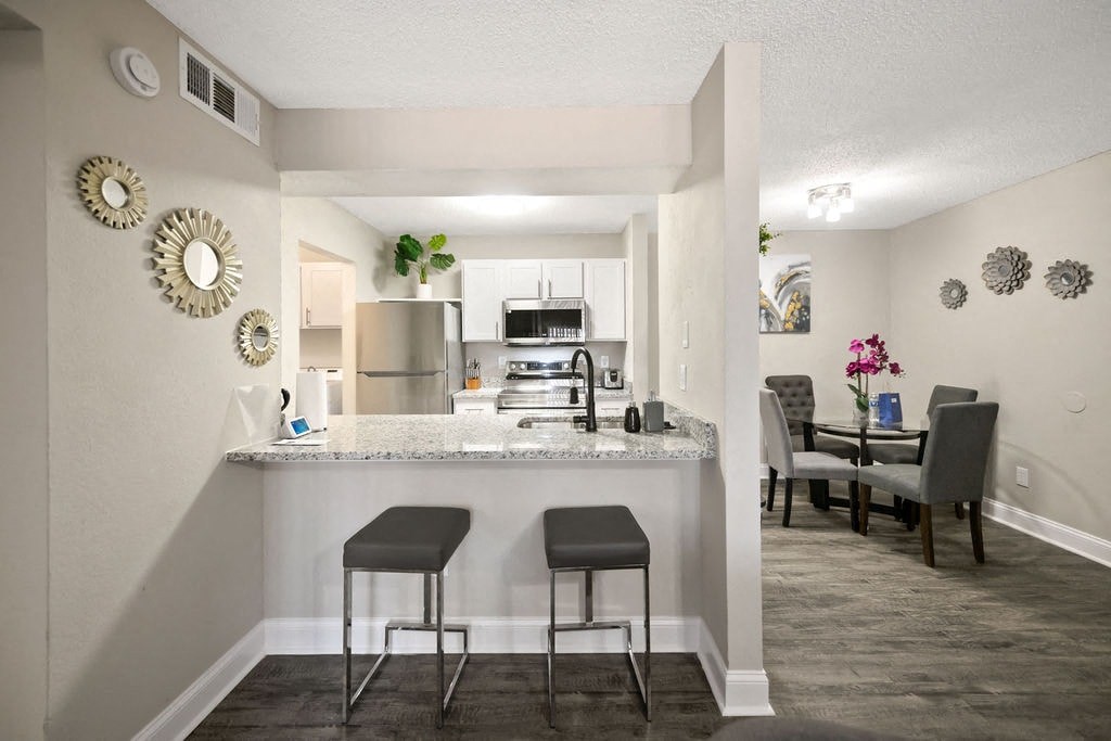 A kitchen with a bar area and a dining table.