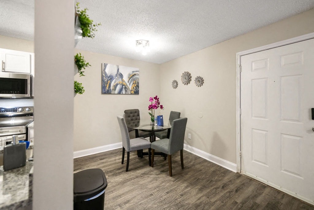 A dining room with a table and chairs.