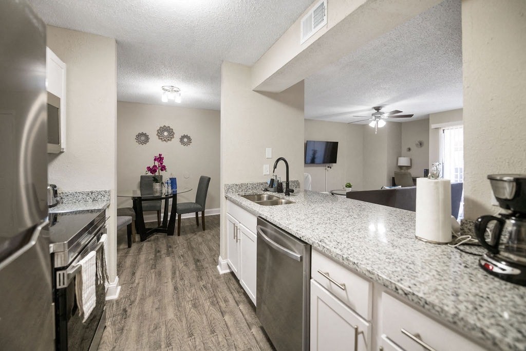 A kitchen with a dining table and chairs in the middle.