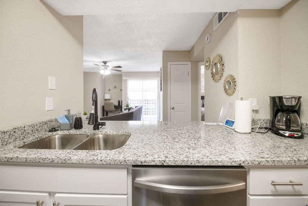 A kitchen with a granite countertop and stainless steel appliances.