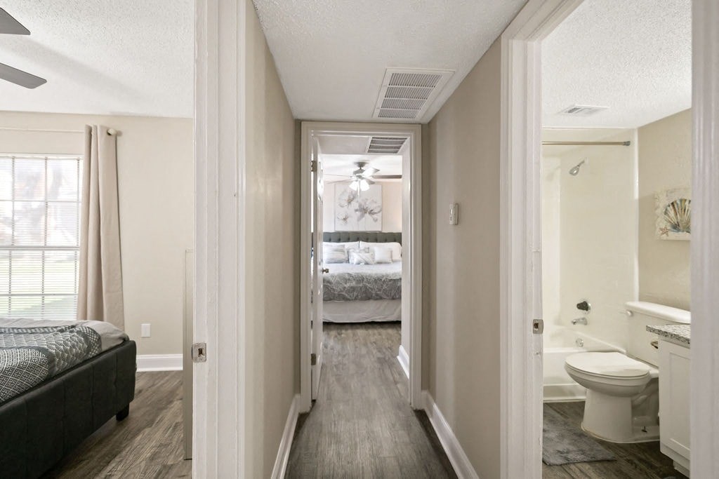 A bedroom with a bed, a toilet, and a bathtub.