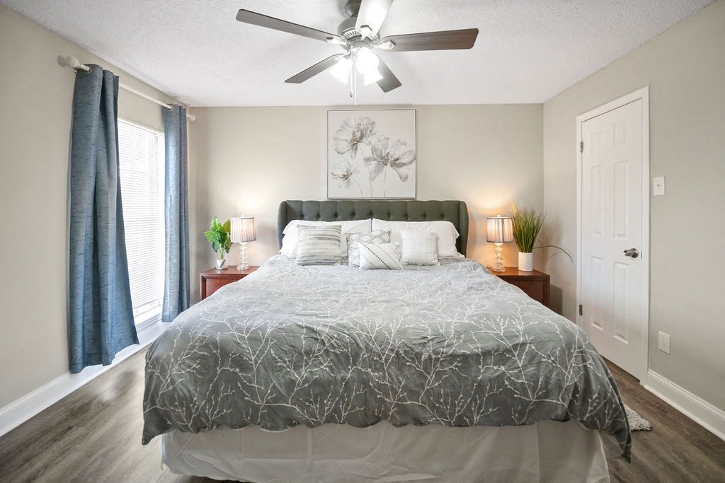 A bedroom with a large bed and a ceiling fan.
