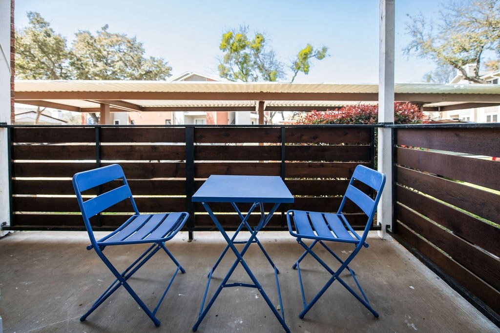 A blue folding chair and table on a patio.
