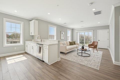 A modern kitchen with stainless steel appliances and wooden floors.