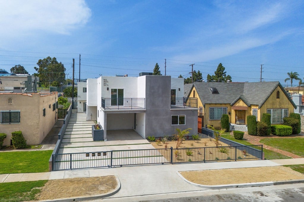 A modern house with a grey exterior and a black gate.