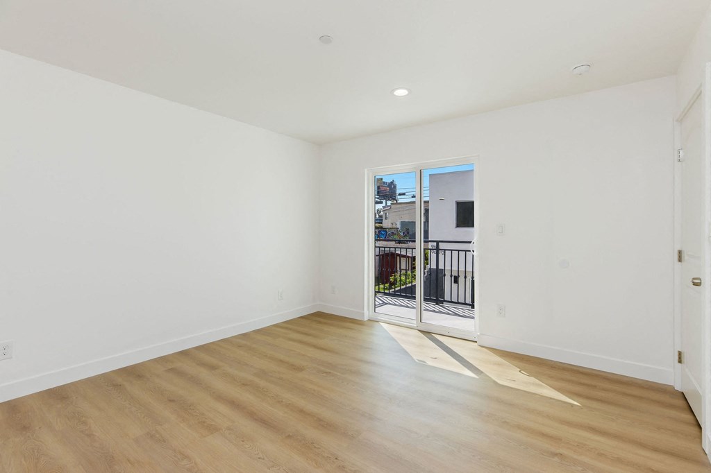 A room with wooden flooring and white walls.