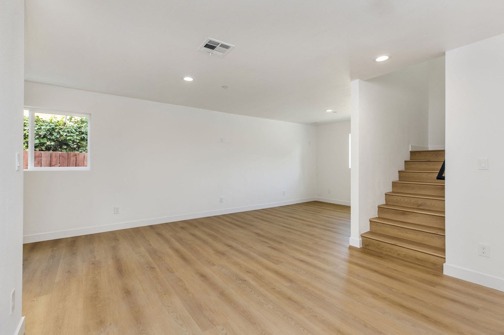 A room with wooden floors and a staircase.
