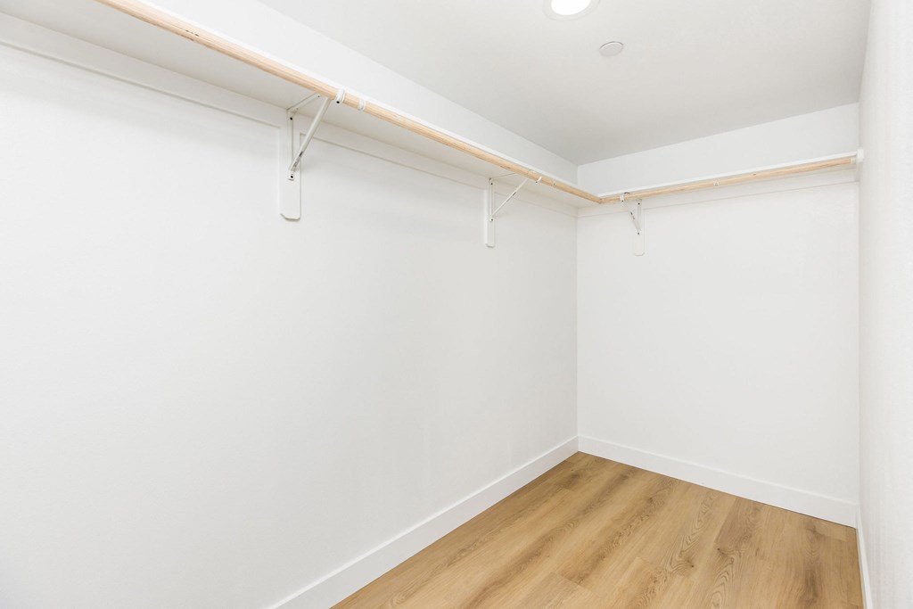A white wall with a wooden floor and a white ceiling.