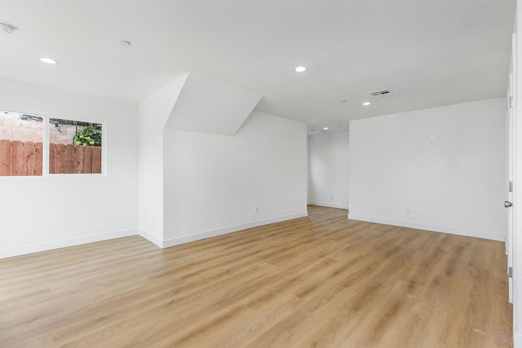 A room with wooden flooring and white walls.
