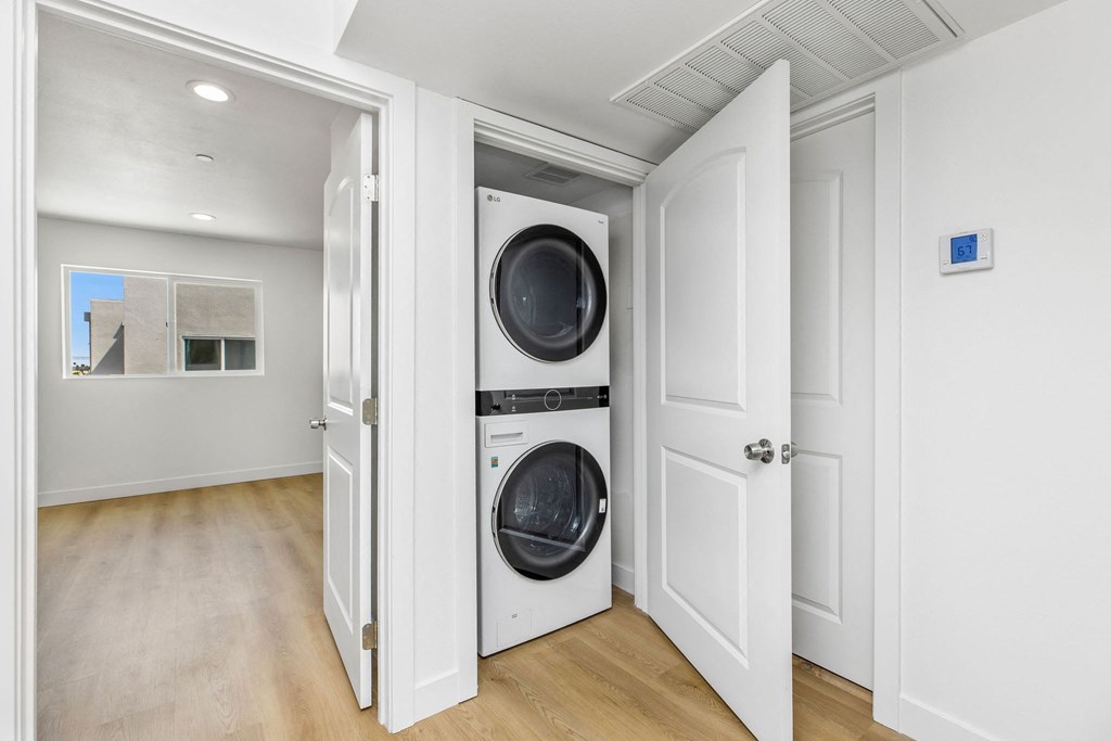 A white laundry room with a washer and dryer in it.