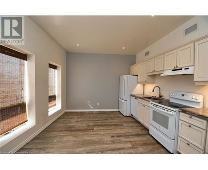 A kitchen with white appliances and wooden floors.
