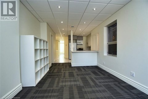 A long hallway with a carpeted floor and white walls.