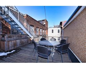 A patio with a table and chairs is surrounded by brick buildings.