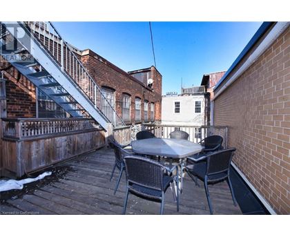 A patio with a table and chairs is surrounded by brick buildings.