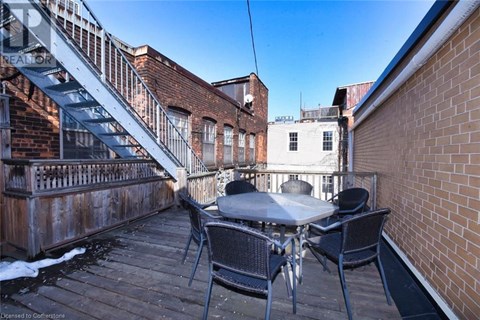 A patio with a table and chairs is surrounded by brick buildings.