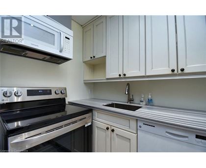 A kitchen with white cabinets and a black stove top oven.