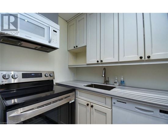 A kitchen with white cabinets and a black stove top oven.