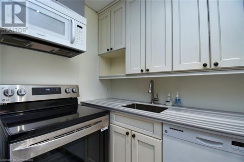 A kitchen with white cabinets and a black stove top oven.