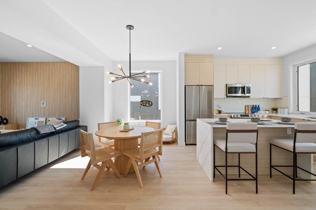 A modern kitchen with a dining table and chairs.