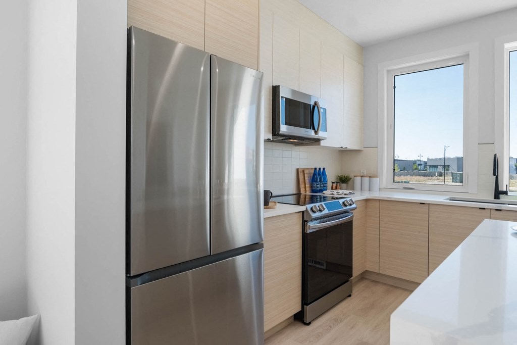 A modern kitchen with a stainless steel refrigerator and wooden cabinets.