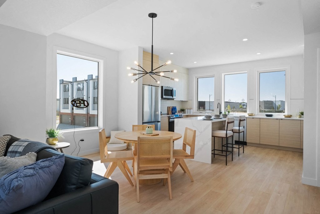 A modern kitchen with a dining table and chairs.