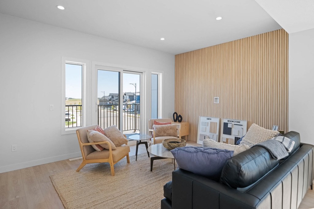 A living room with a black couch, a wooden chair, and a coffee table.