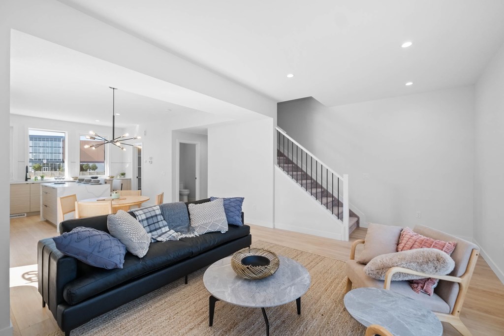 A living room with a black couch and a coffee table.