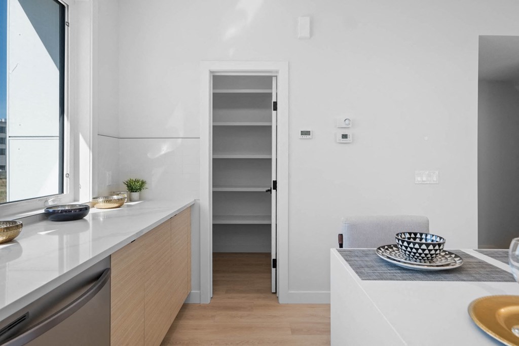 A kitchen with a white counter and a white chair.