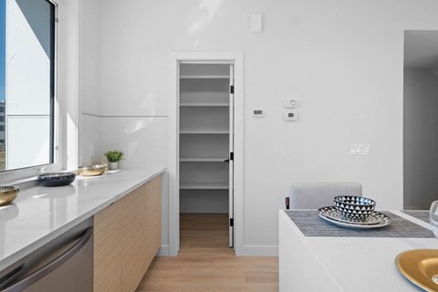 A kitchen with a white counter and a white chair.