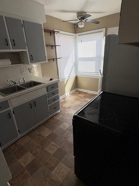 A kitchen with a black stove top oven and a fan on the ceiling.