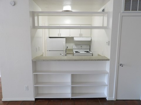 A kitchen with white cabinets and a white counter top.